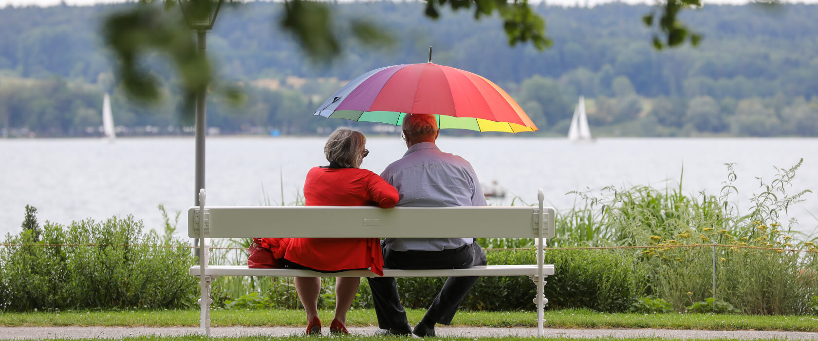 Ehepaar auf Parkbank mit Blick auf See
