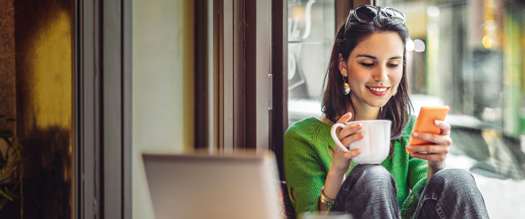 Frau mit Smartphone in einem Cafe