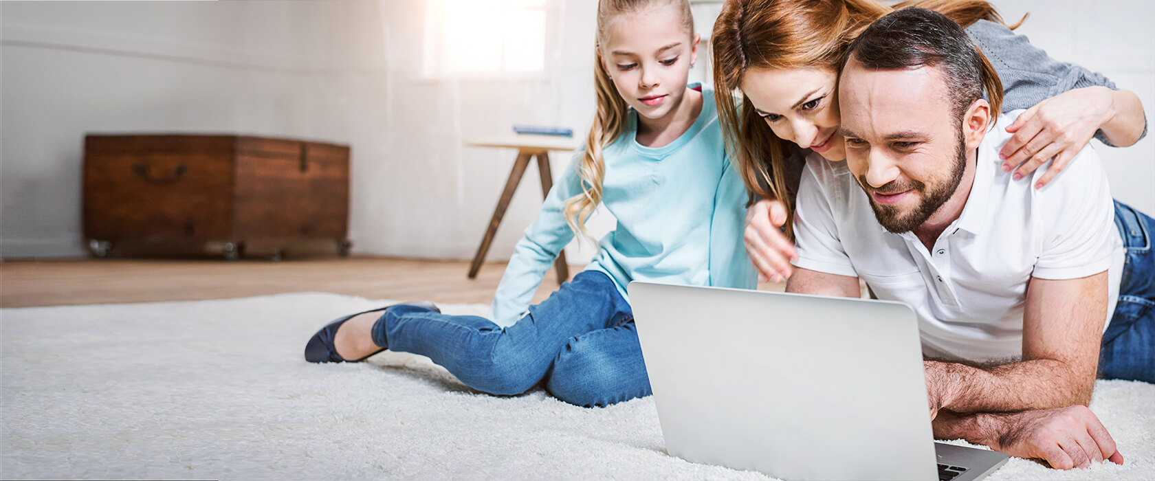 Familie guckt interessiert auf einen Laptop