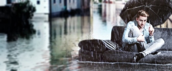Mann sitzt auf Sofa mit Regenschirm auf überfluteter Straße