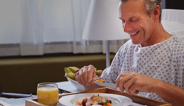 Mann beim Essen im Krankenbett