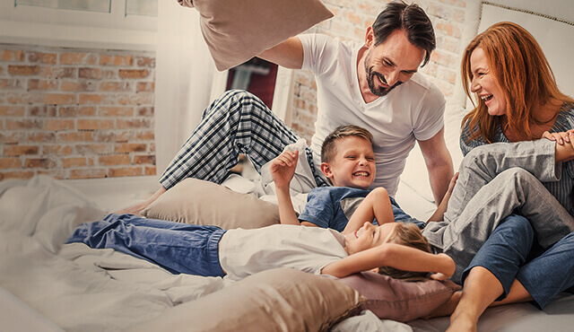 Familie tobt im Bett