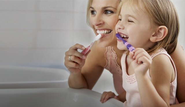 Mutter und Tochter putzen Zähne