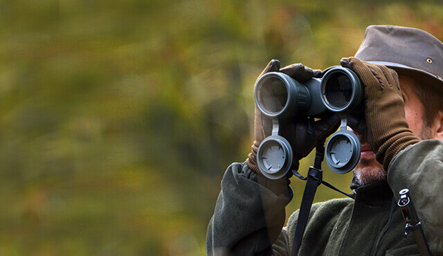 Jäger guckt durch Fernglas