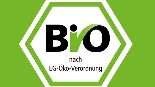 Hexagonales Logo mit dem Schriftzug „Bio“ und der Aufschrift „nach EG-Öko-Verordnung“ auf grünem Hintergrund.