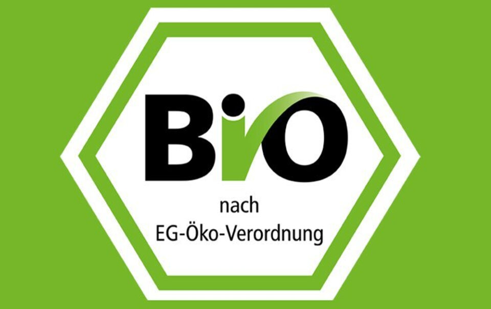 Hexagonales Logo mit dem Schriftzug „Bio“ und der Aufschrift „nach EG-Öko-Verordnung“ auf grünem Hintergrund.