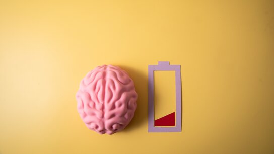 Comicansicht von einem Gehirn und einen fast leeren Akkuanzeige auf gelben Hintergrund.