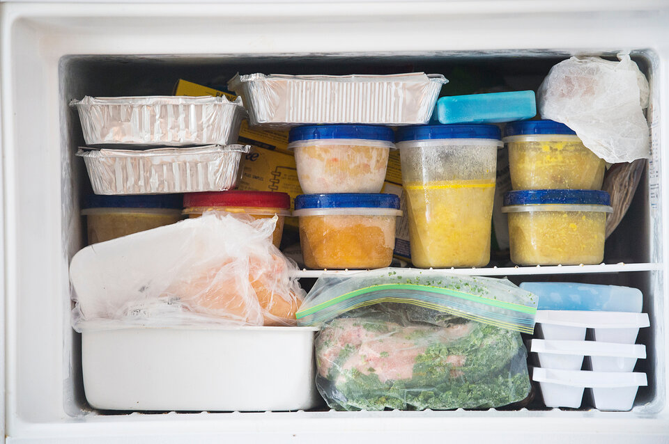 Gefrierfach mit verschiedenen Behältern, gefrorenem Gemüse, und Portionen in Aufbewahrungsboxen.