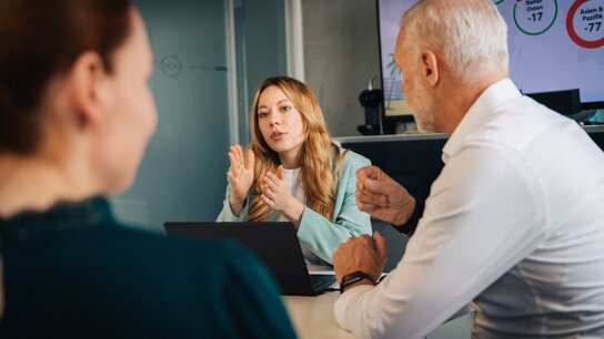 Geschäftsfrau im Gespräch mit zwei Kollegen