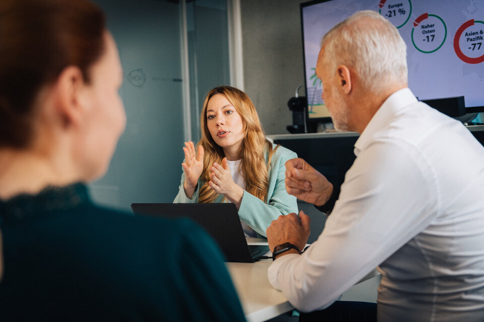 Geschäftsfrau im Gespräch mit zwei Kollegen