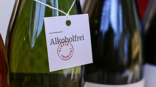 Ein Etikett an einer Flasche mit der Aufschrift „Alkoholfrei“ und dem Stempel „Hierin probiert“.