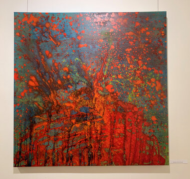 Abstrakte Farbsplatter in intensiven Rot- und Blautönen, mit grünen Akzenten und dynamischen, fließenden Strukturen.