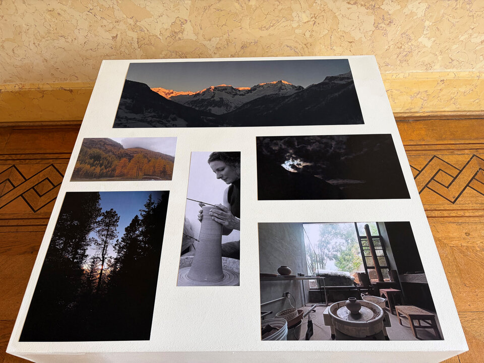 Sechs verschiedene Fotografien auf einem weißen Tisch, darunter Landschaften, Porträts und Innenräume.