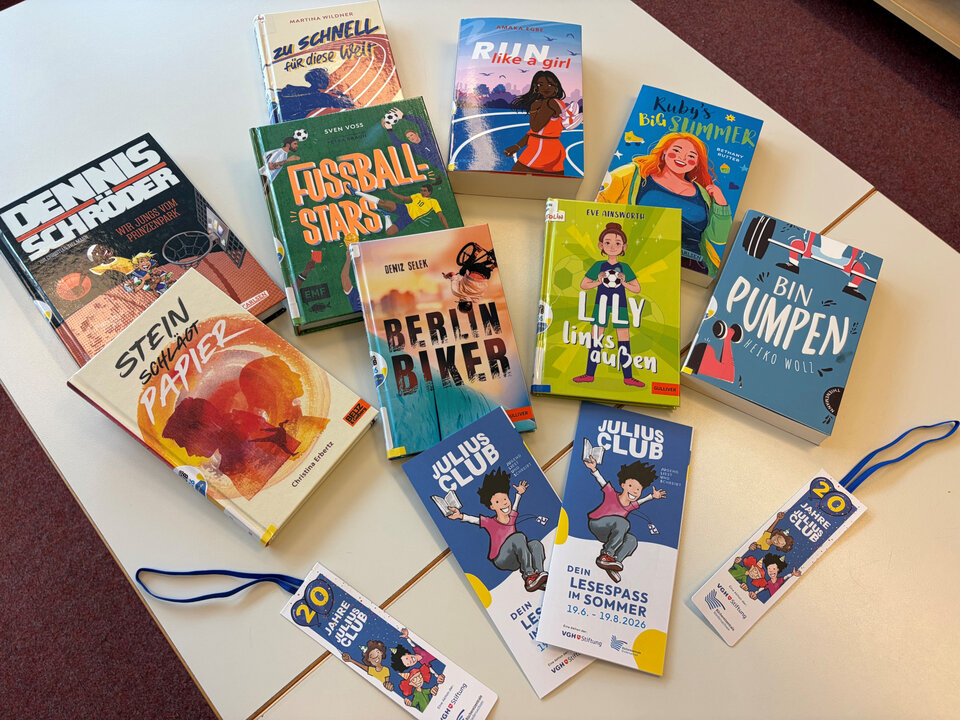 Auf einem Tisch liegen mehrere Bücher und Lesezeichen in bunten Designs. Die Titel sind gut sichtbar, darunter „Fussball Stars“ und „Lilly links laufen“.