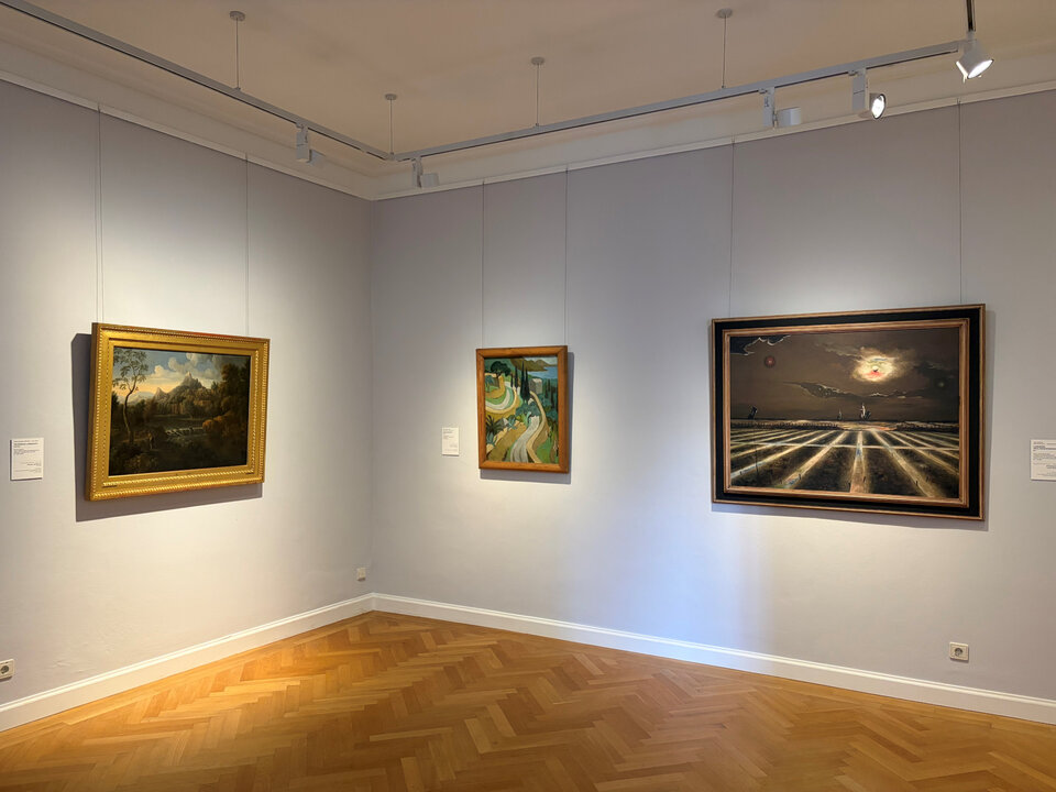 Drei Gemälde in einer Galerie, eines mit Landschaft, eines mit abstrakten Formen und das dritte mit einer dramatischen Himmelsszene.