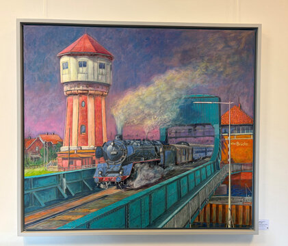 Dampflokomotive fährt über eine Brücke, im Hintergrund ein Wasserturm und mehrere Gebäude unter einem farbenfrohen Himmel.