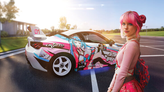 Junge Frau mit pinkem Haar steht neben einem bunten, mit Anime-Motiven bedruckten Sportwagen auf einem Parkplatz.